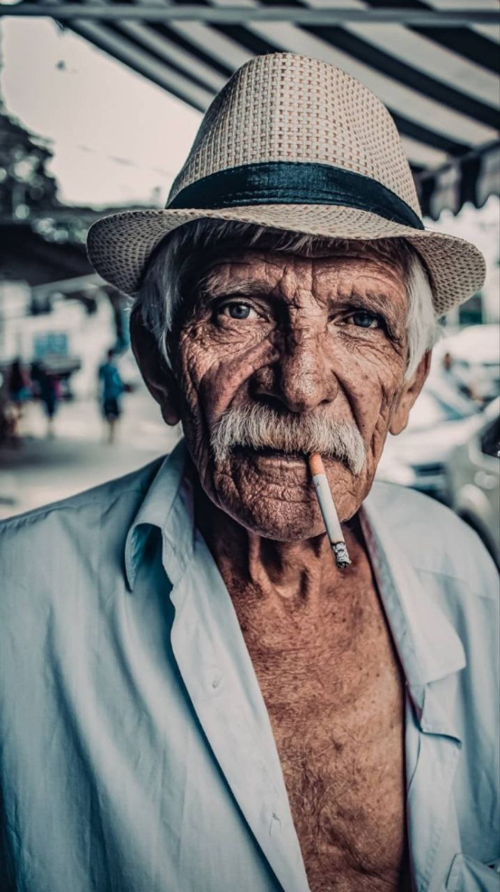a man with a hat smoking a cigarette